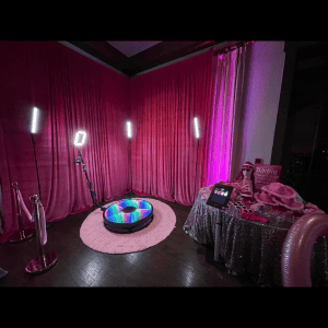 Elegant photo booth setup with pink curtains and colorful lighting in Atlanta.