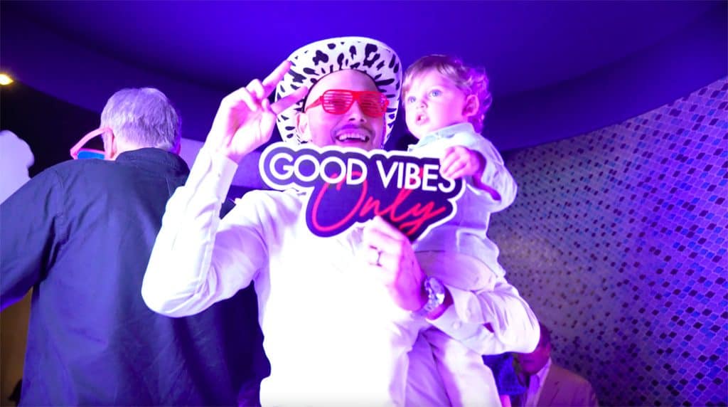 People enjoying a photo booth at an event in Atlanta with a 'Good Vibe Only' sign.
