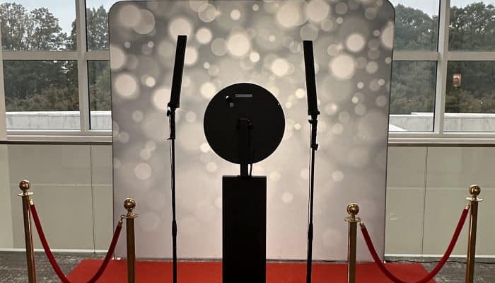 Modern photo booth setup with ring light and backdrop at an event venue.