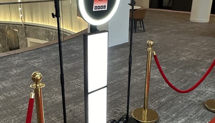 Photo booth with digital screen and lighting at event venue.